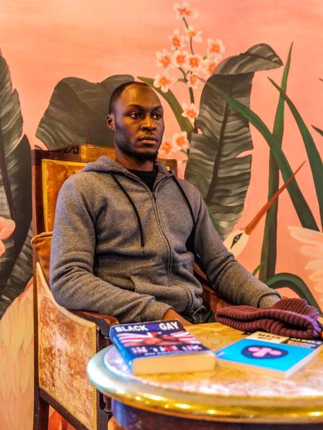 A man seated at a table with BLKOUT materials at Black Men Who Brunch