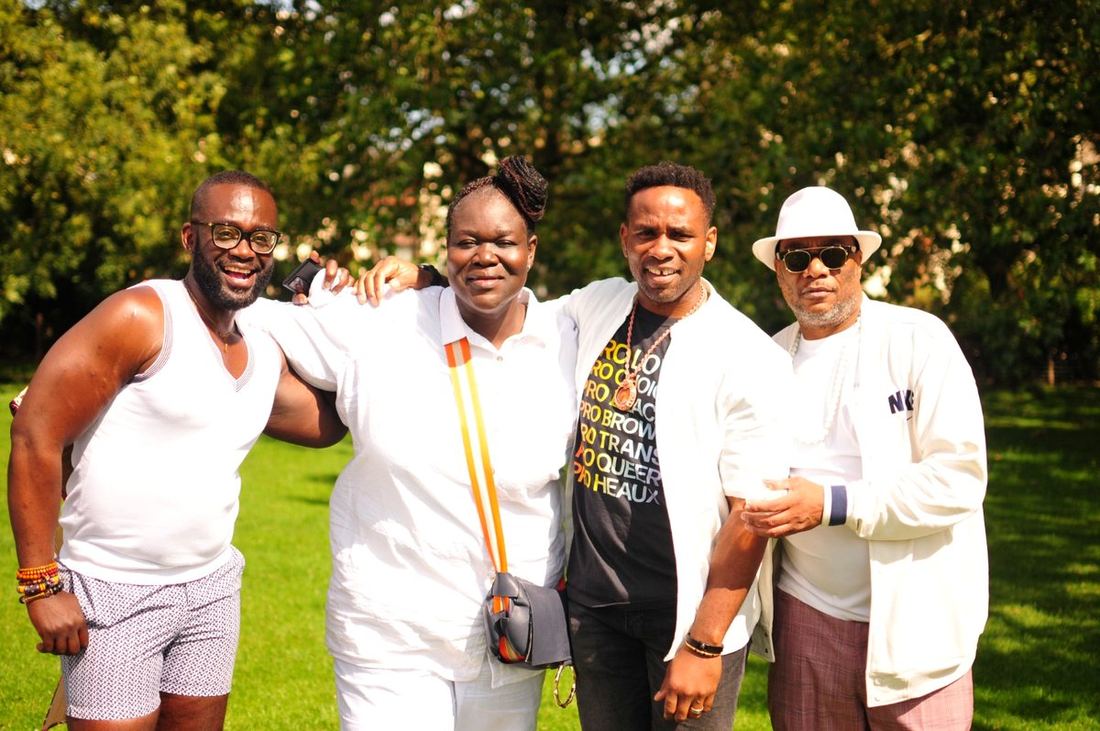 A group of Black queer men dressed in white at the BLKOUT annual picnic, August 2023